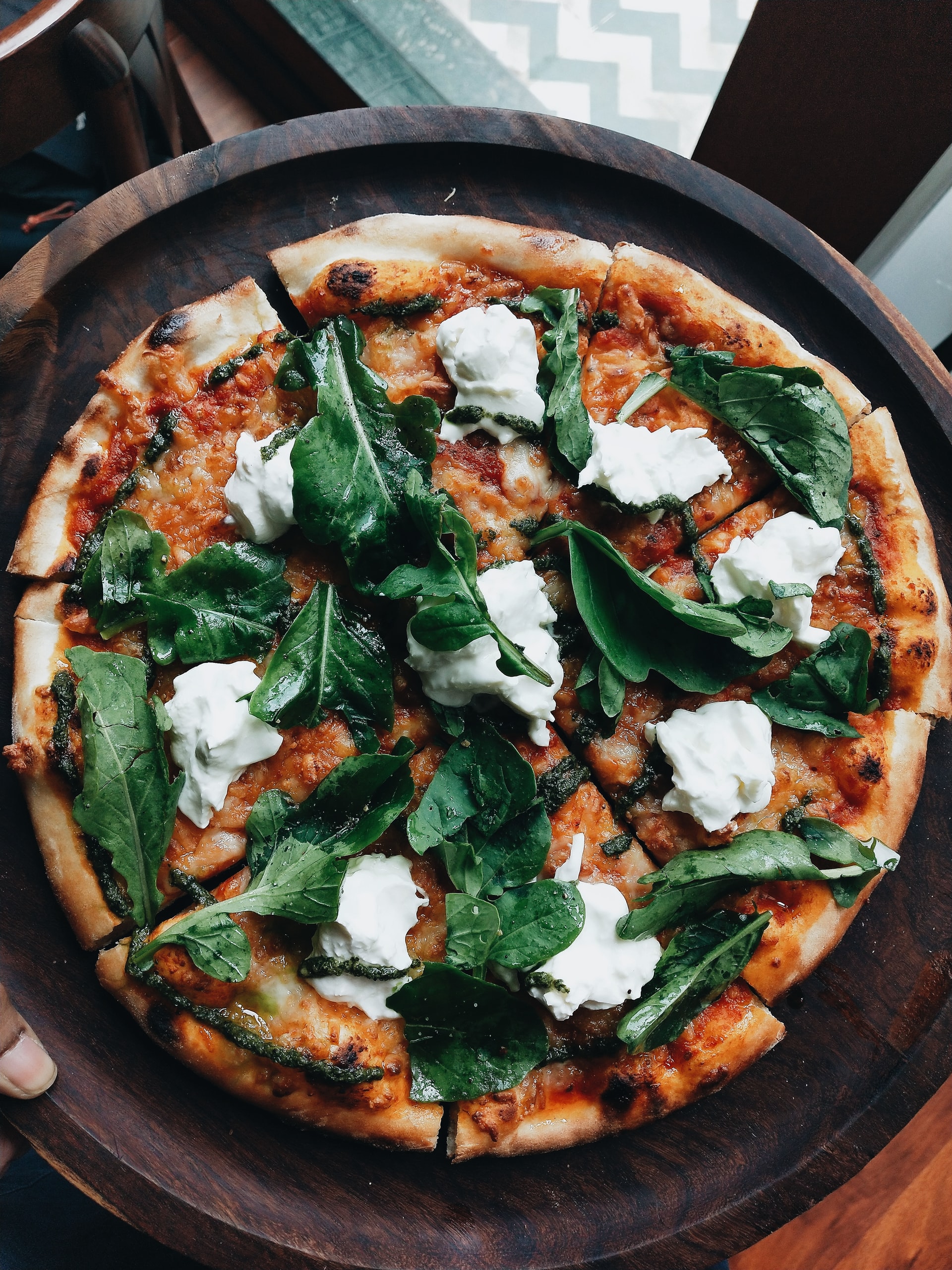 An oven-baked pizza with pesto, rocket and buffalo mozzarella.